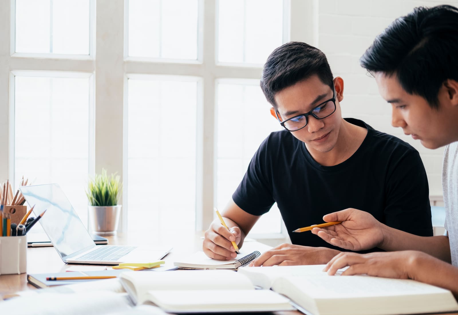 Studierende lernen gemeinsam mit Büchern für die Abschlussarbeit